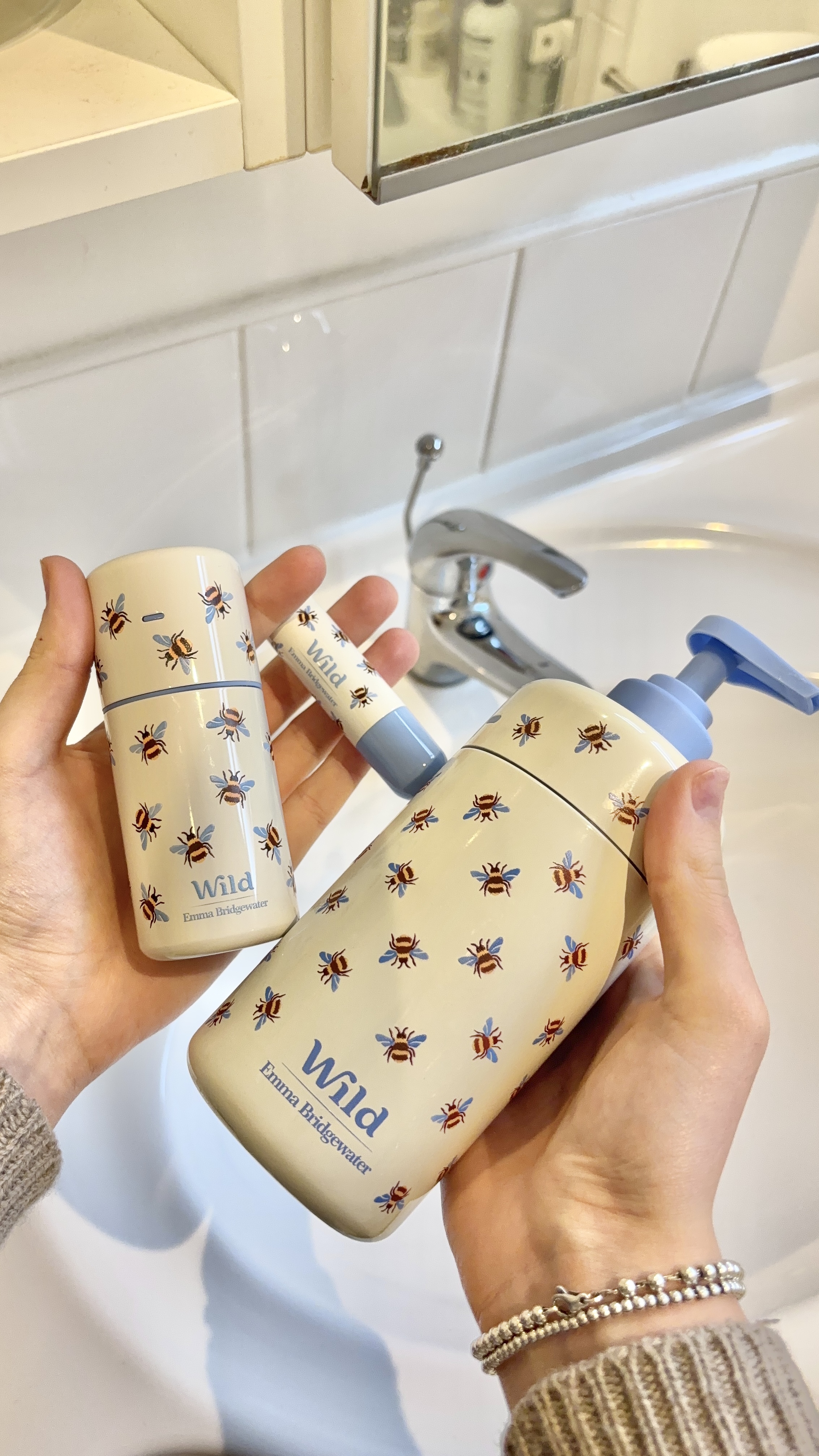 Caption: a woman is holding a baby bottle in front of a sink