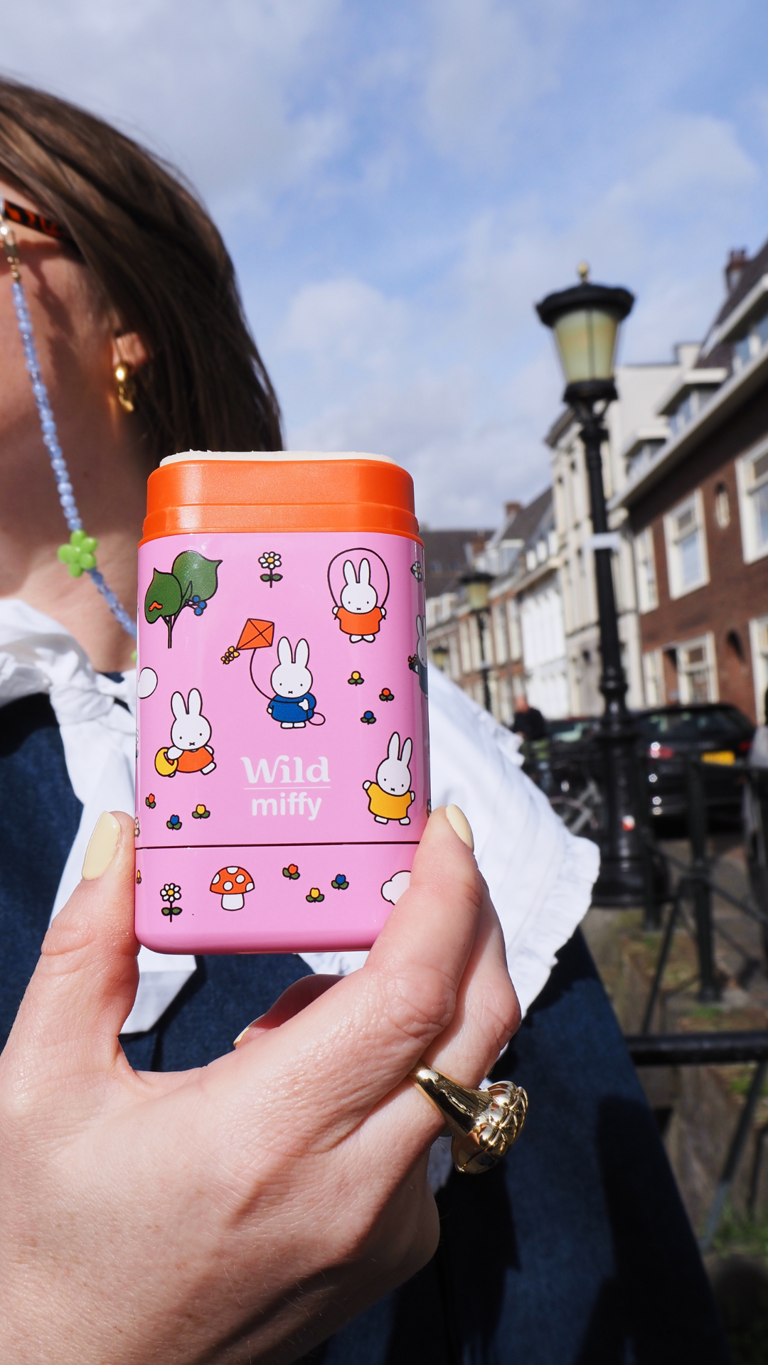 Caption: a woman holding a pink case with cartoon characters on it