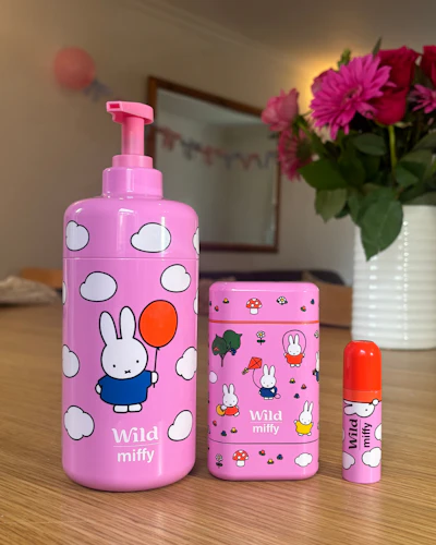 Bildunterschrift: Eine Flasche Lotion und ein Tiegel Lippenbalsam auf einem Tisch