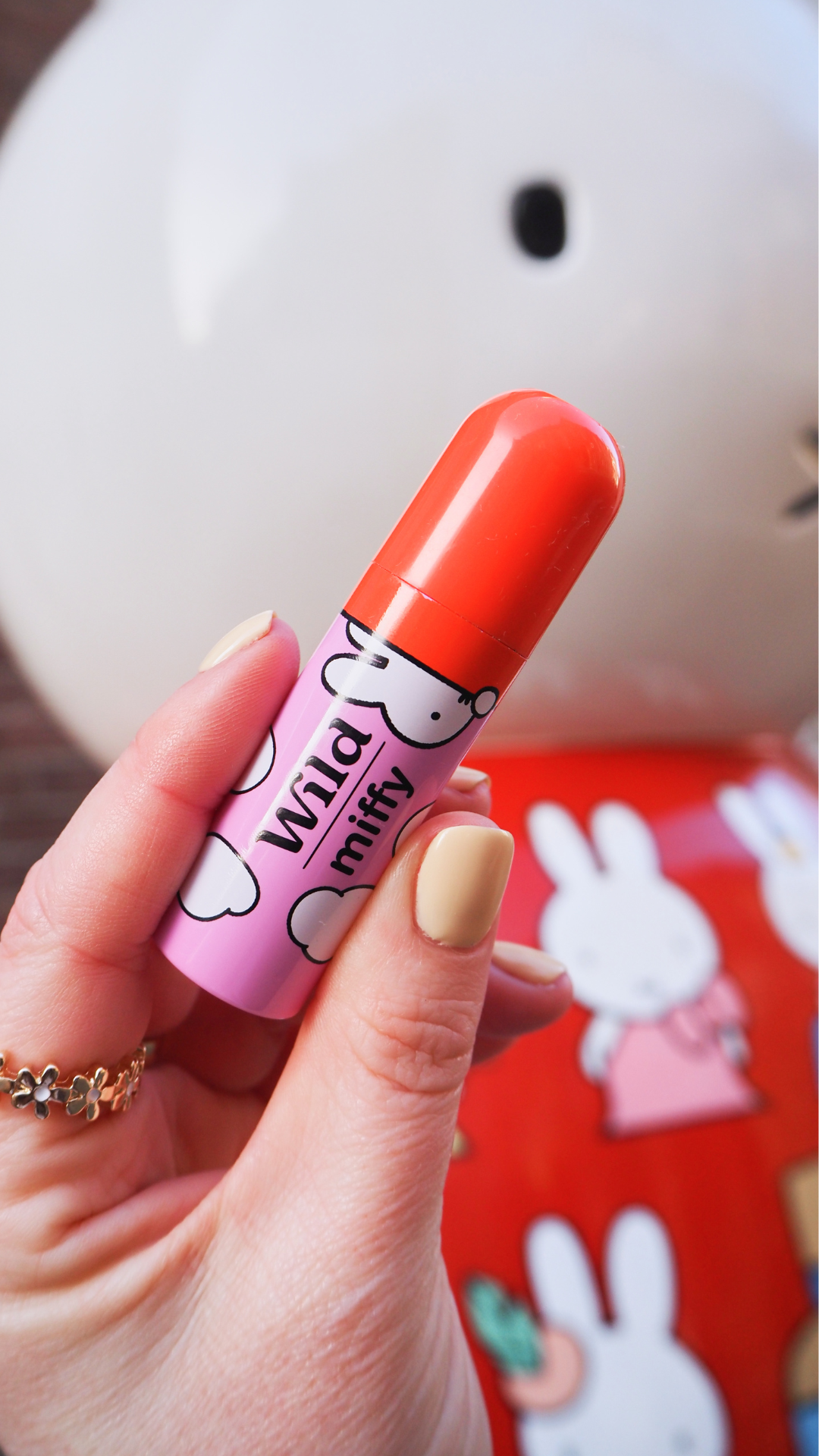 Caption: a person holding a lip bale in their hand