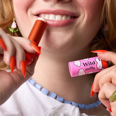 Bildunterschrift: Eine Frau hält einen Lippenstift in der Hand