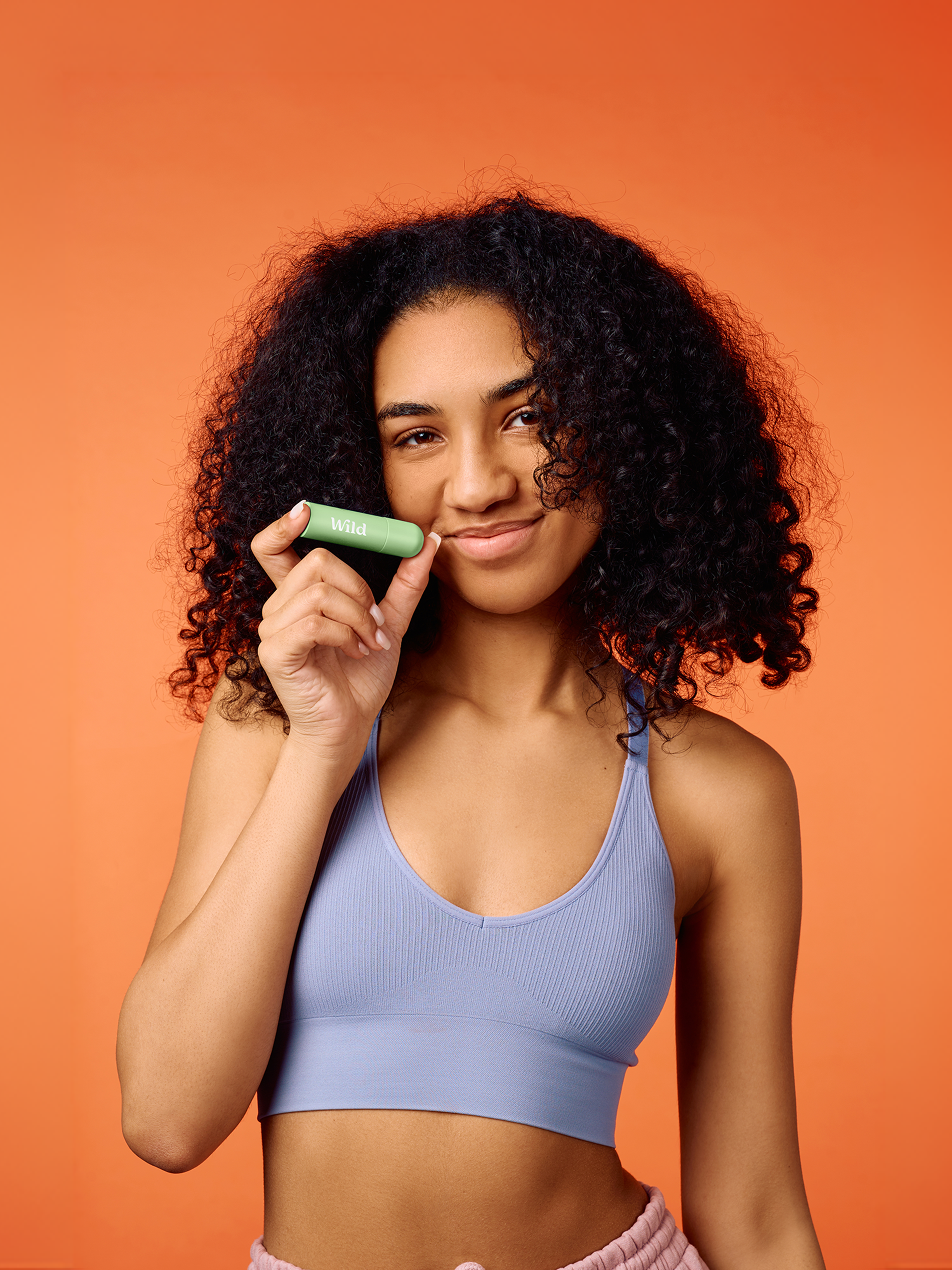 Caption: a woman in a sports bra holding a green object