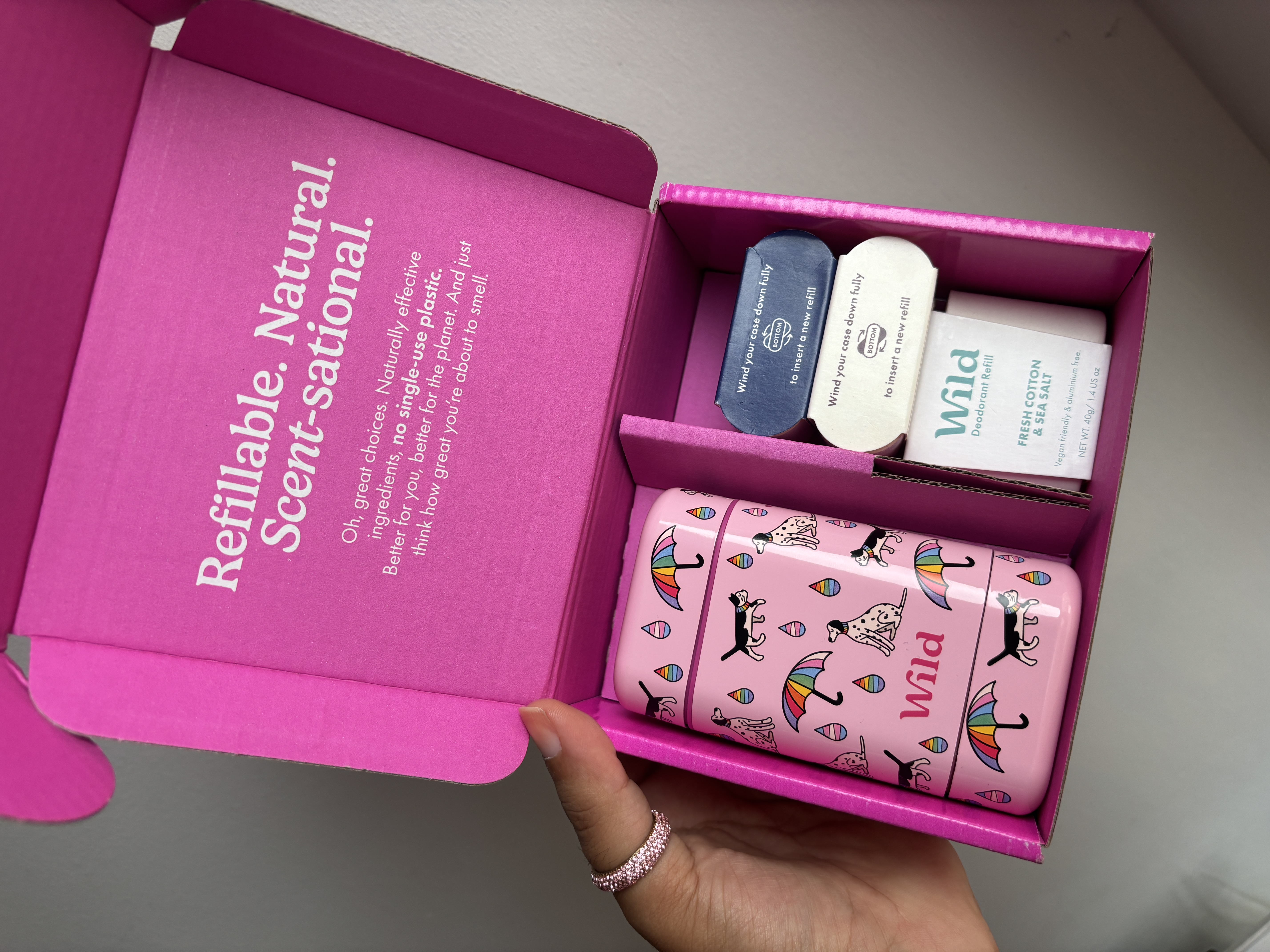 Caption: a person is holding a pink box with personal care items in it
