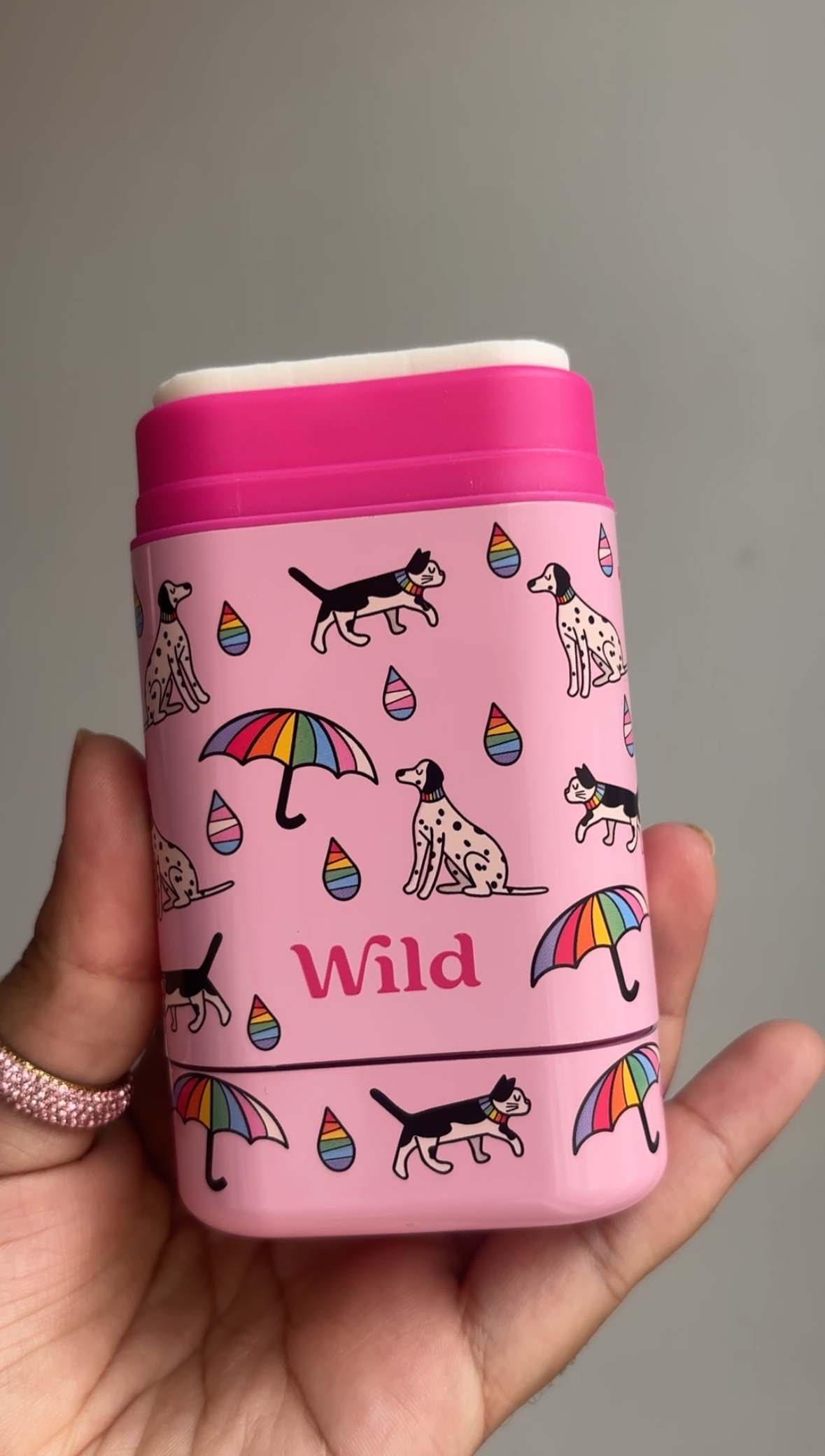 Caption: a person holding a pink cup with dogs and umbrellas on it