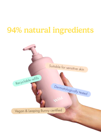 Caption: a hand holding a pink bottle with labels on it