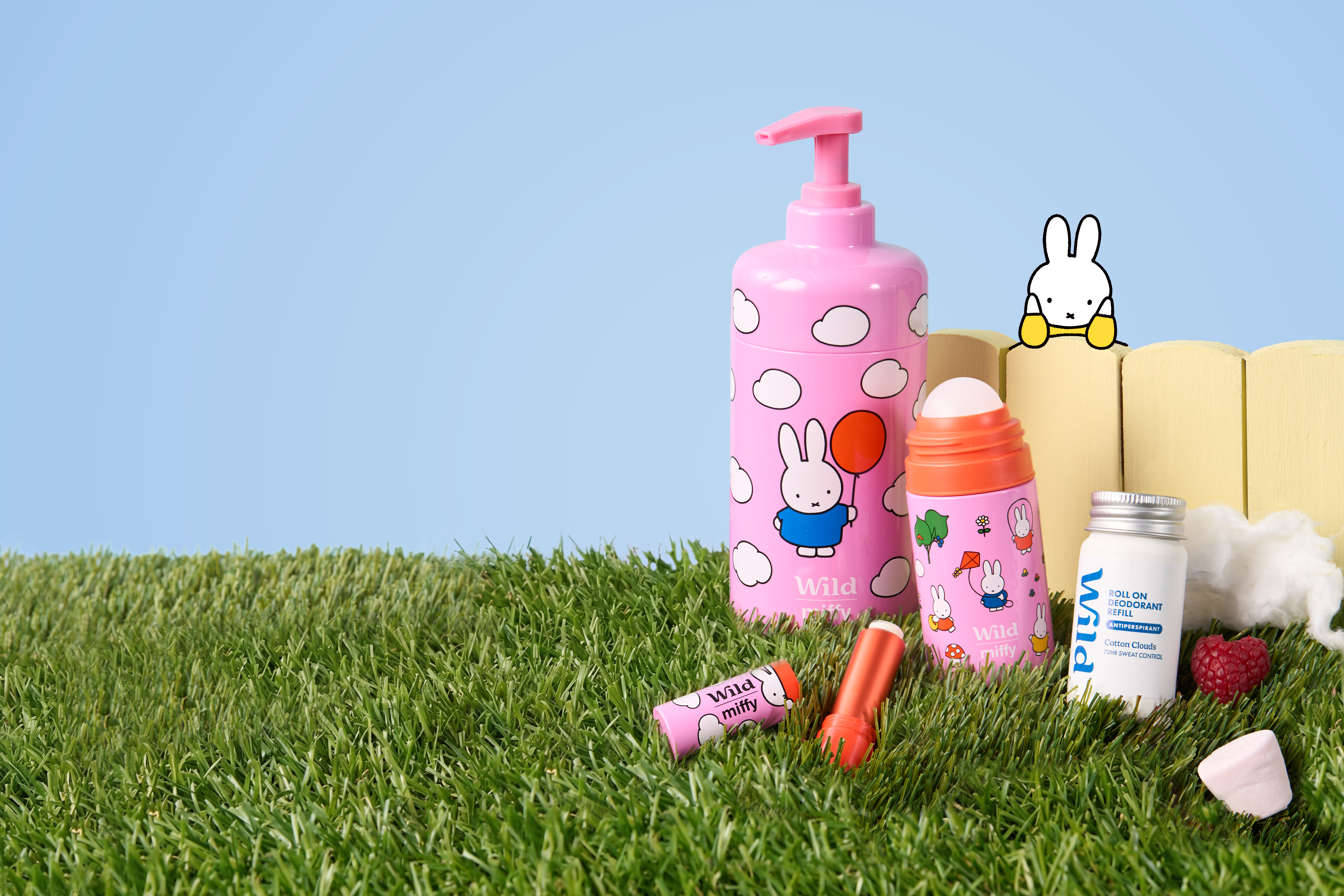 Caption: a couple of bottles of toothpaste sitting on top of a lush green field