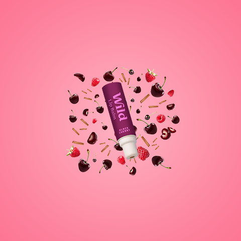 Bildunterschrift: Eine Tube Lippenbalsam, umgeben von Pralinen und Erdbeeren