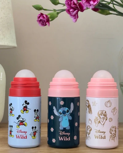 Caption: three baby bottles sitting on a table next to a vase of flowers