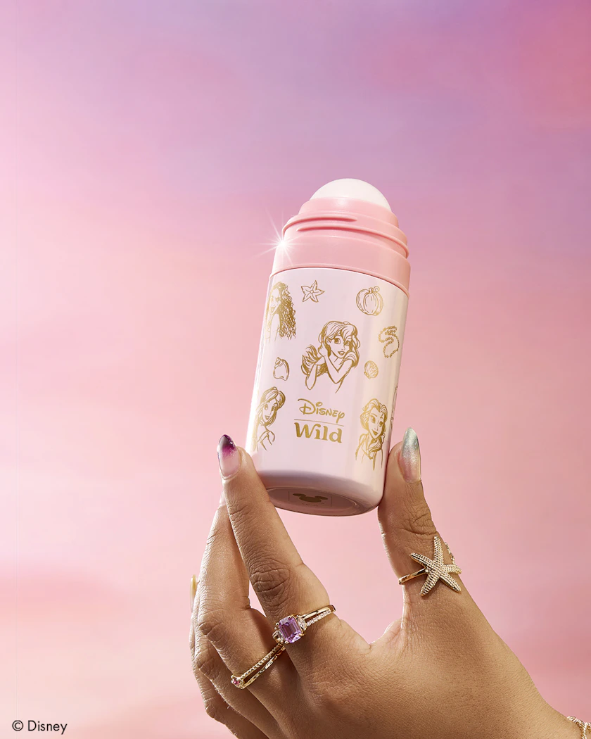 Caption: a woman holding a pink and white cup with disney characters on it