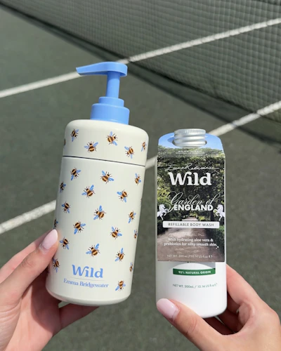 Caption: a person holding a bottle of hand sanitizer next to a tennis net
