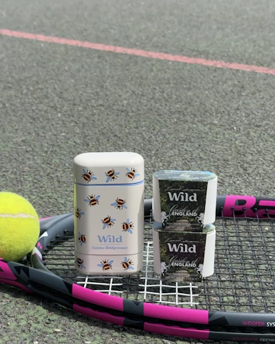 Caption: a tennis racket with a cup of coffee and a ball on it
