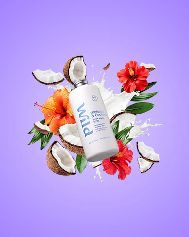 Caption: a bottle of lotion surrounded by flowers and coconuts