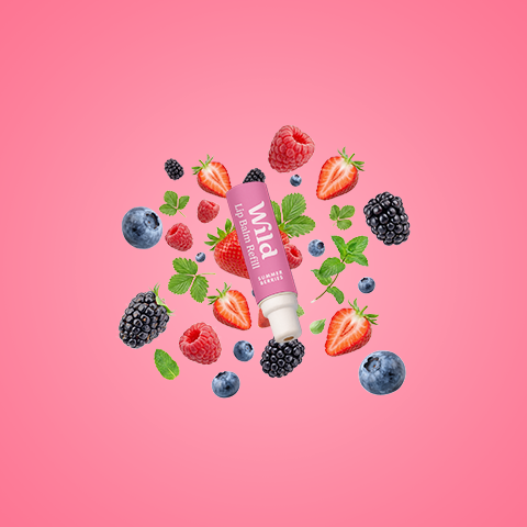 Caption: a tube of lip balm surrounded by berries and strawberries