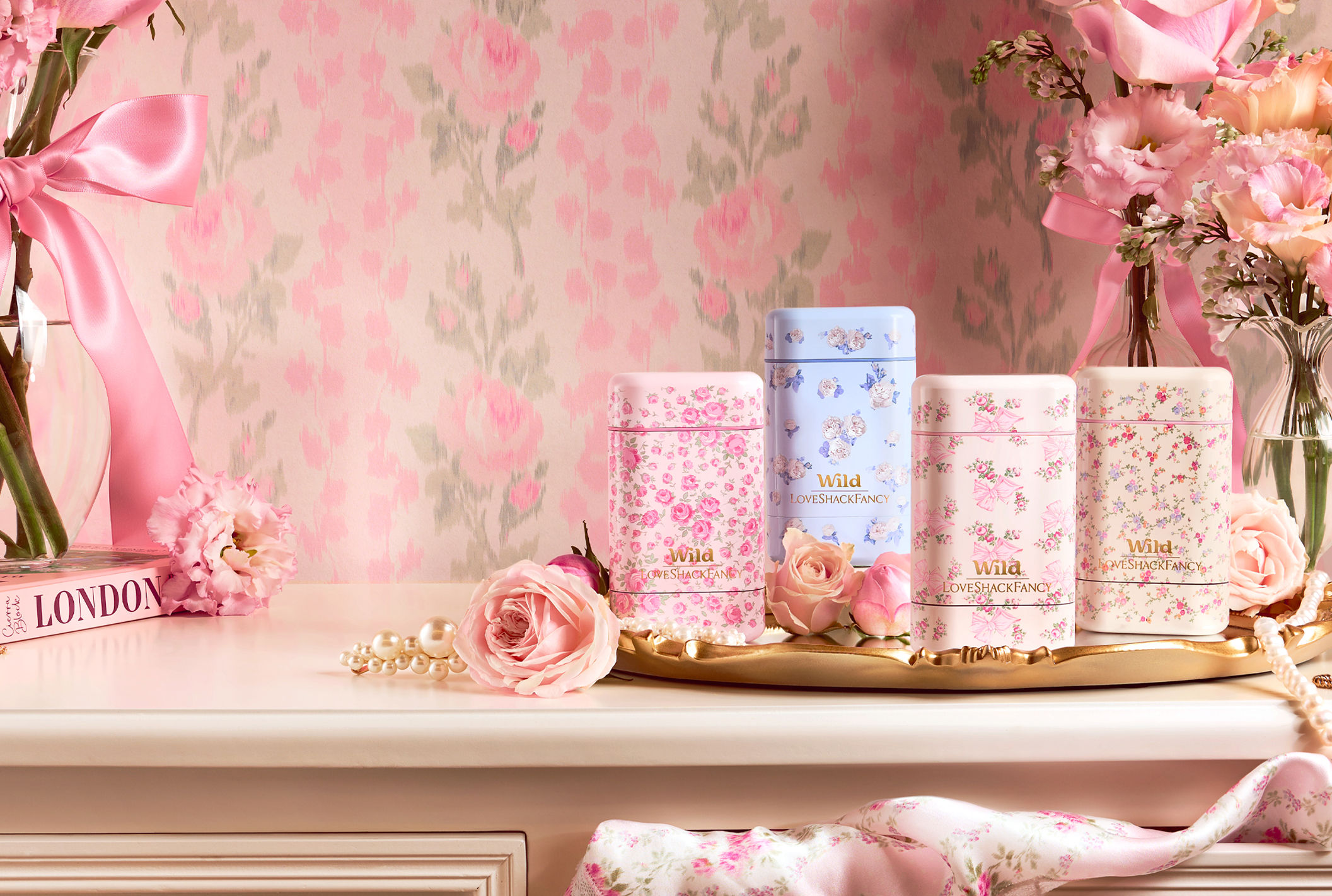Caption: a table topped with lots of pink flowers next to a vase filled with flowers