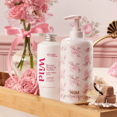 Caption: a bottle of lotion, soap, and a vase of pink flowers on a