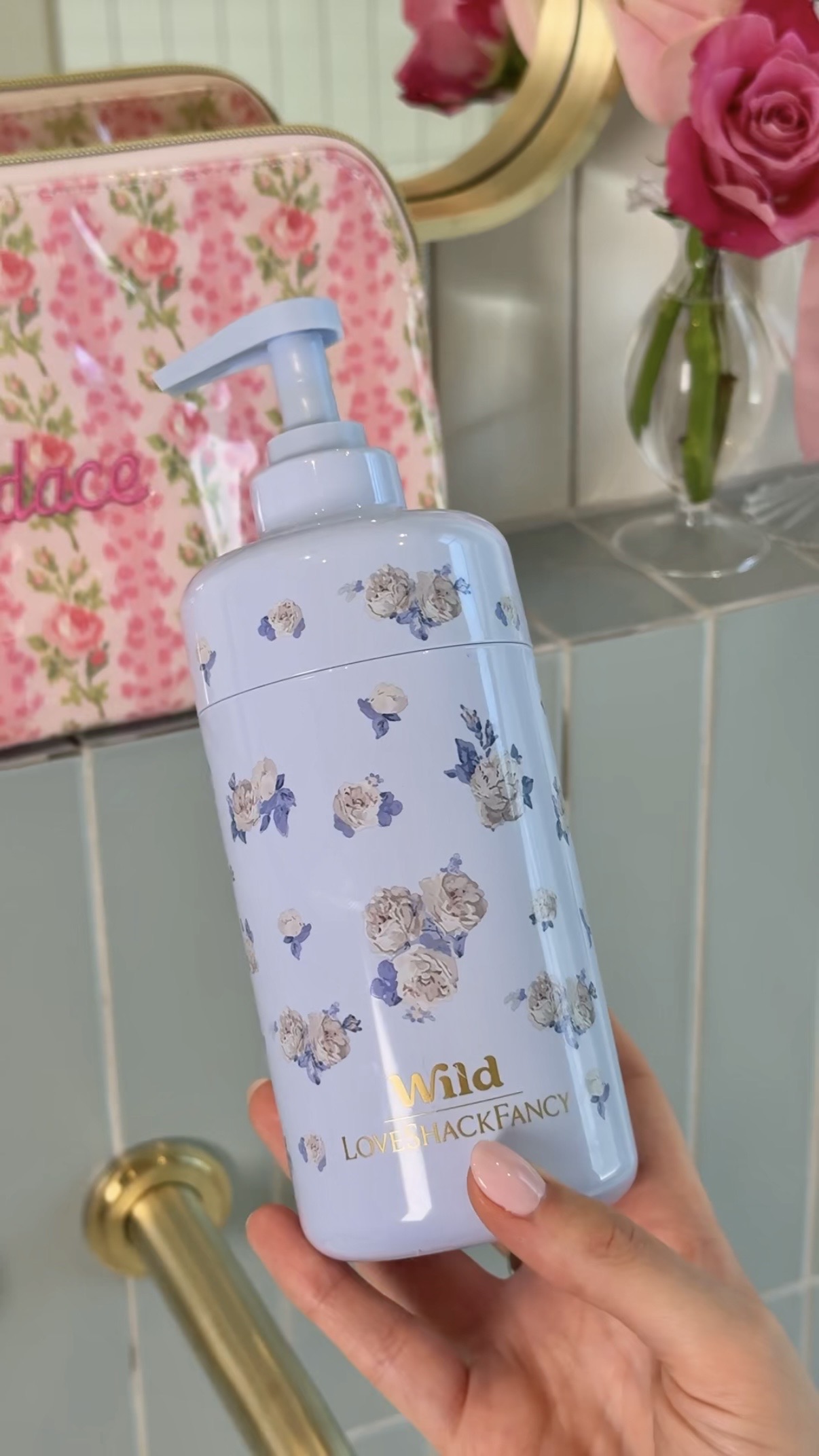 Caption: a hand holding a blue bottle with flowers on it