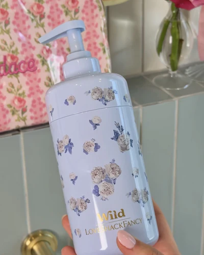 Caption: a hand holding a blue bottle with flowers on it