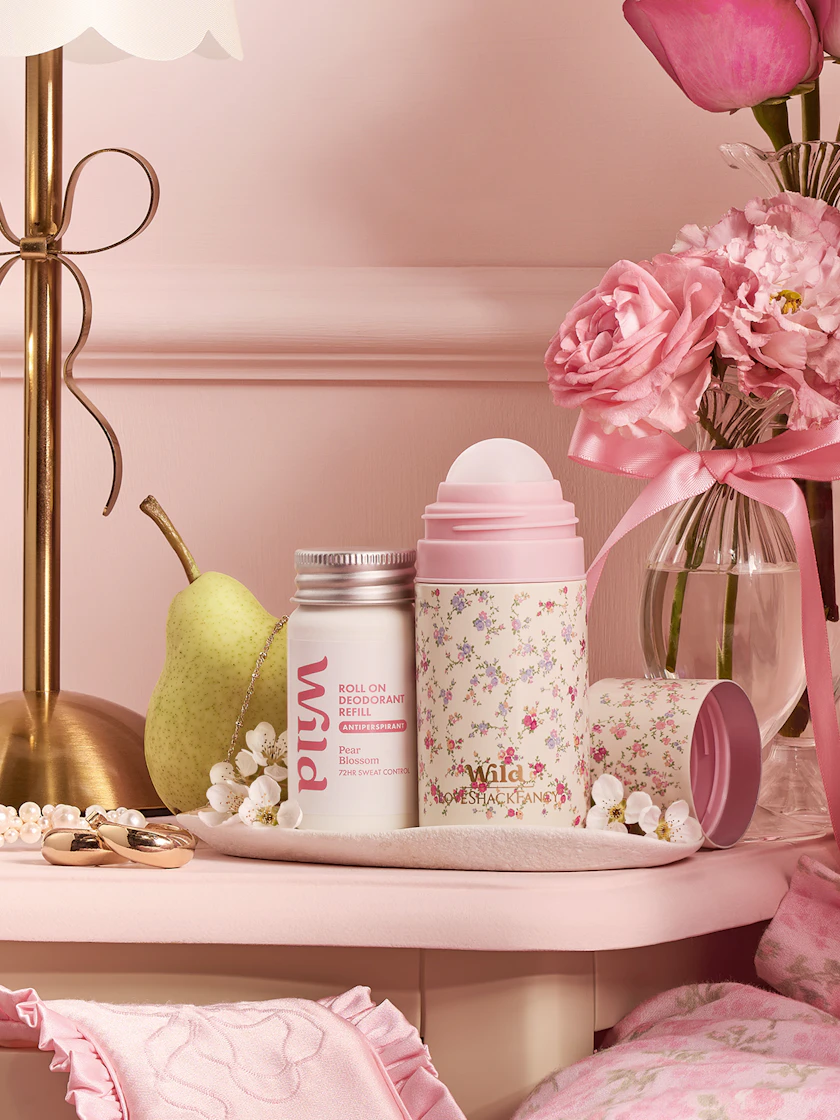 Caption: a table with a vase of flowers, a bottle of lip balm, a