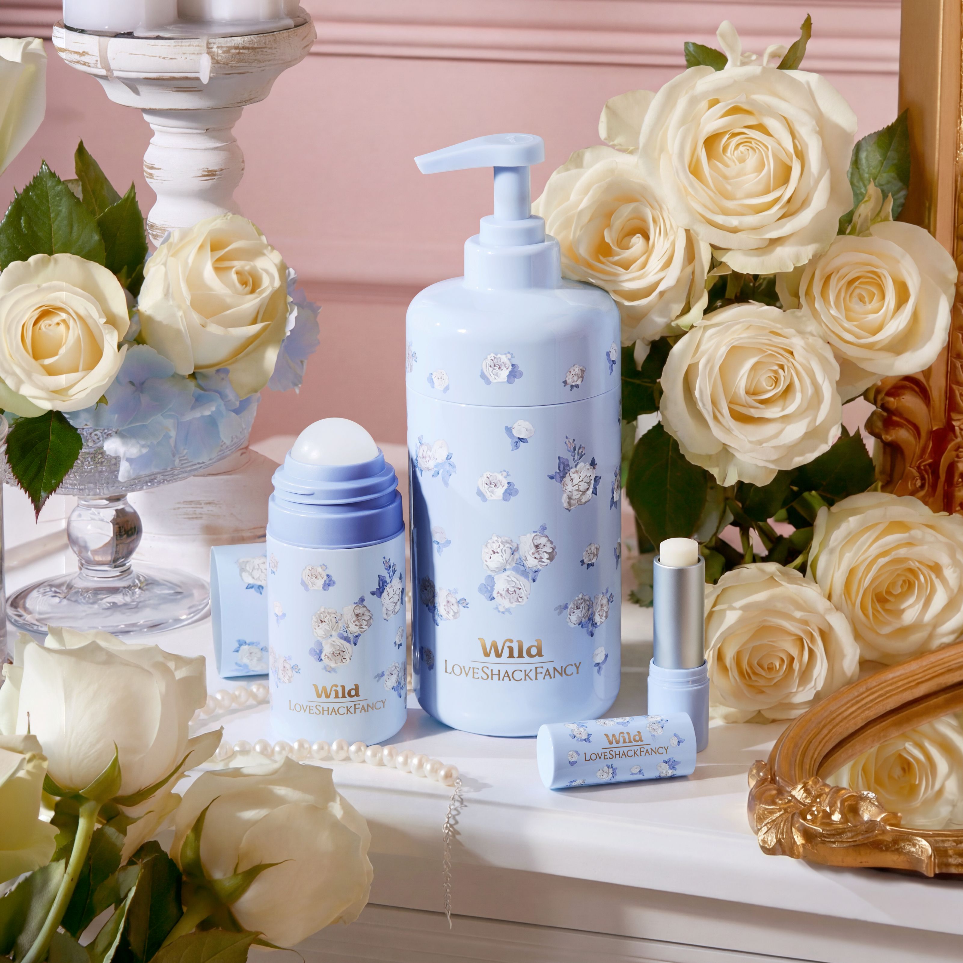 Caption: a table topped with a bottle of lotion next to a vase of flowers