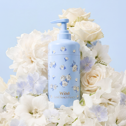 Caption: a bottle of lotion sitting on top of a bouquet of flowers