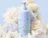Caption: a bottle of lotion sitting on top of a bouquet of flowers