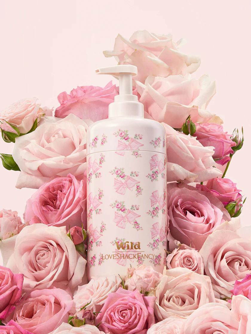 Caption: a bottle of lotion surrounded by pink roses