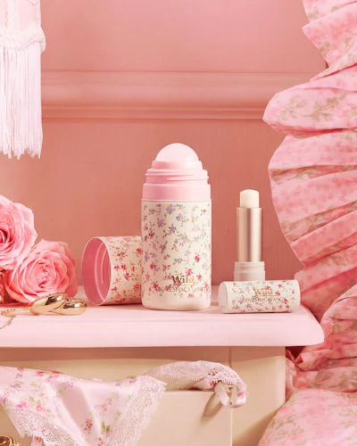 Caption: a pink dresser with pink flowers and a bottle of lipstick
