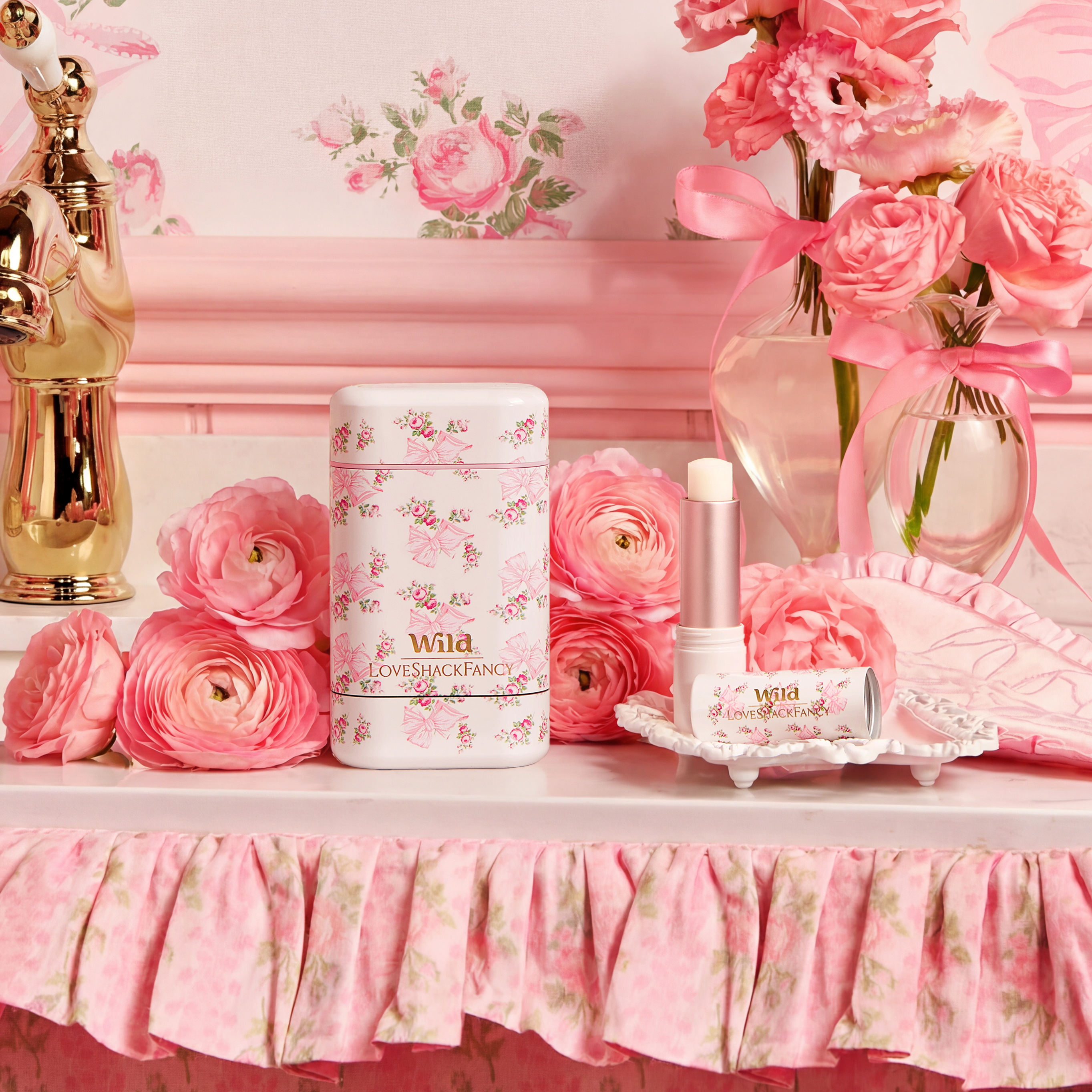 Caption: a table topped with pink flowers and perfume bottles