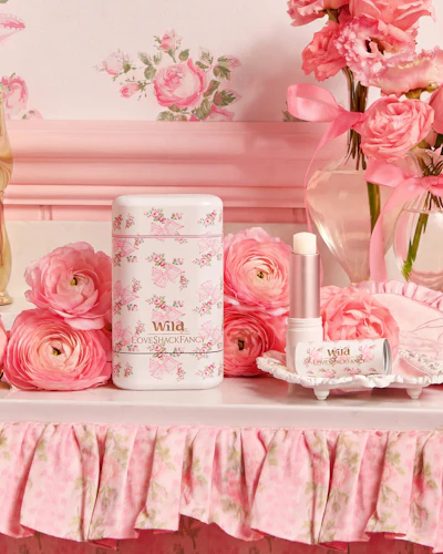 Caption: a table topped with pink flowers and perfume bottles