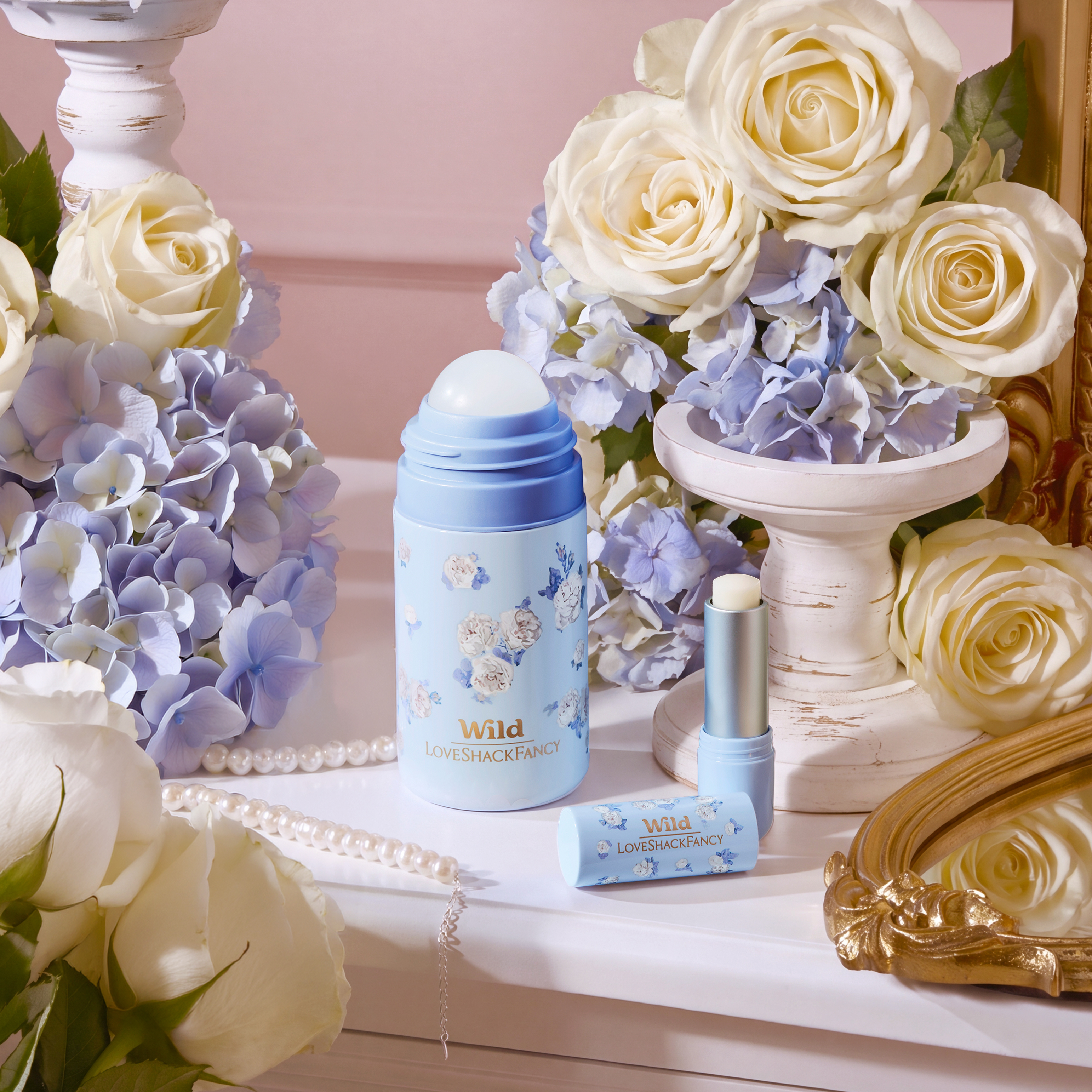 Caption: a vase of flowers and a bottle of perfume