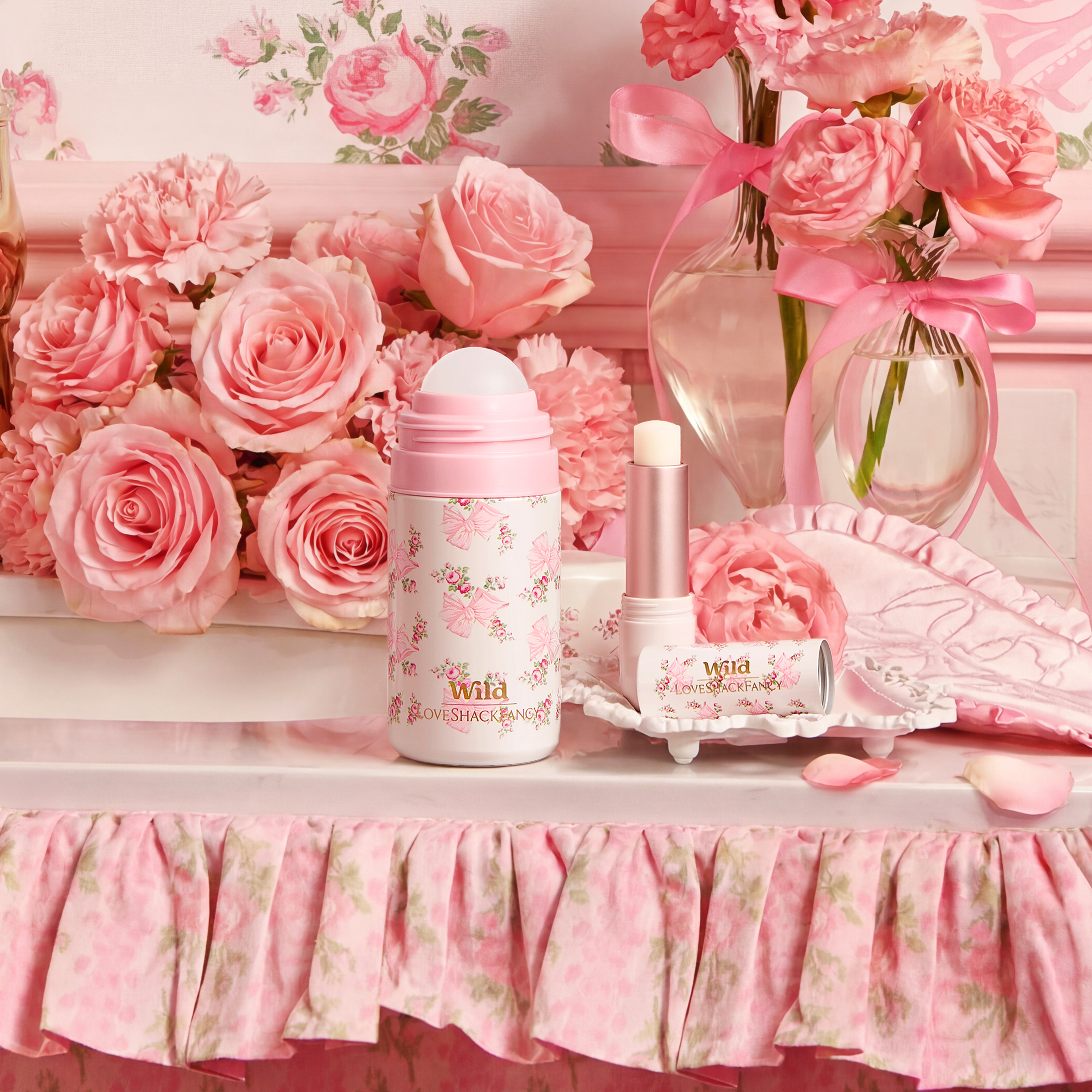 Caption: a table topped with pink flowers and bottles of perfume