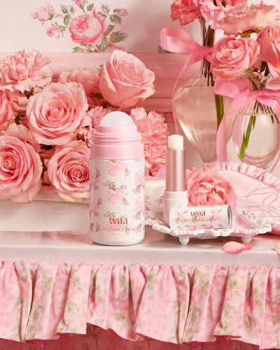 Caption: a table topped with pink flowers and bottles of perfume