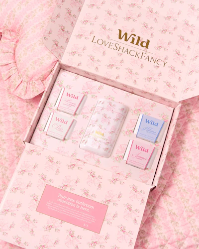 Caption: a pink box with three different perfumes inside of it