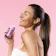 Caption: a woman with a ponytail holding a bottle of hair
