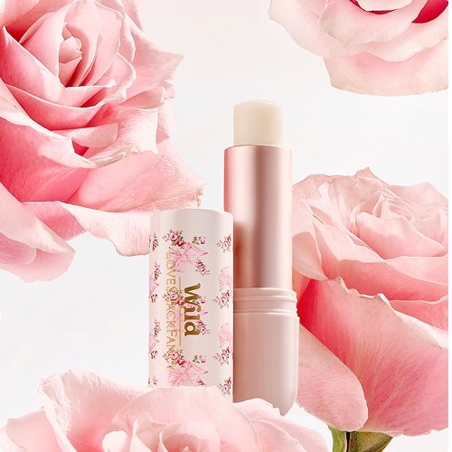 Caption: a close up of a lipstick with pink flowers in the background