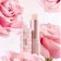 Caption: a close up of a lipstick with pink flowers in the background