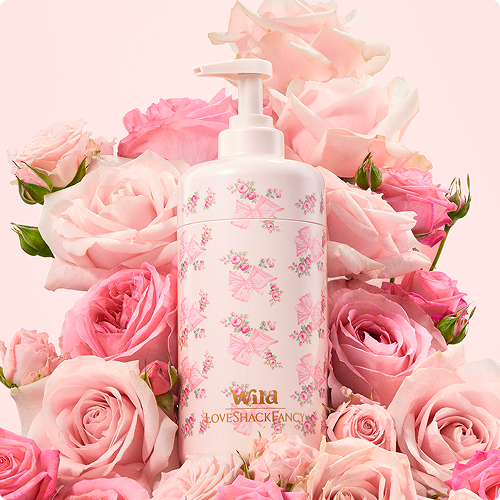 Caption: a bottle of lotion surrounded by pink roses