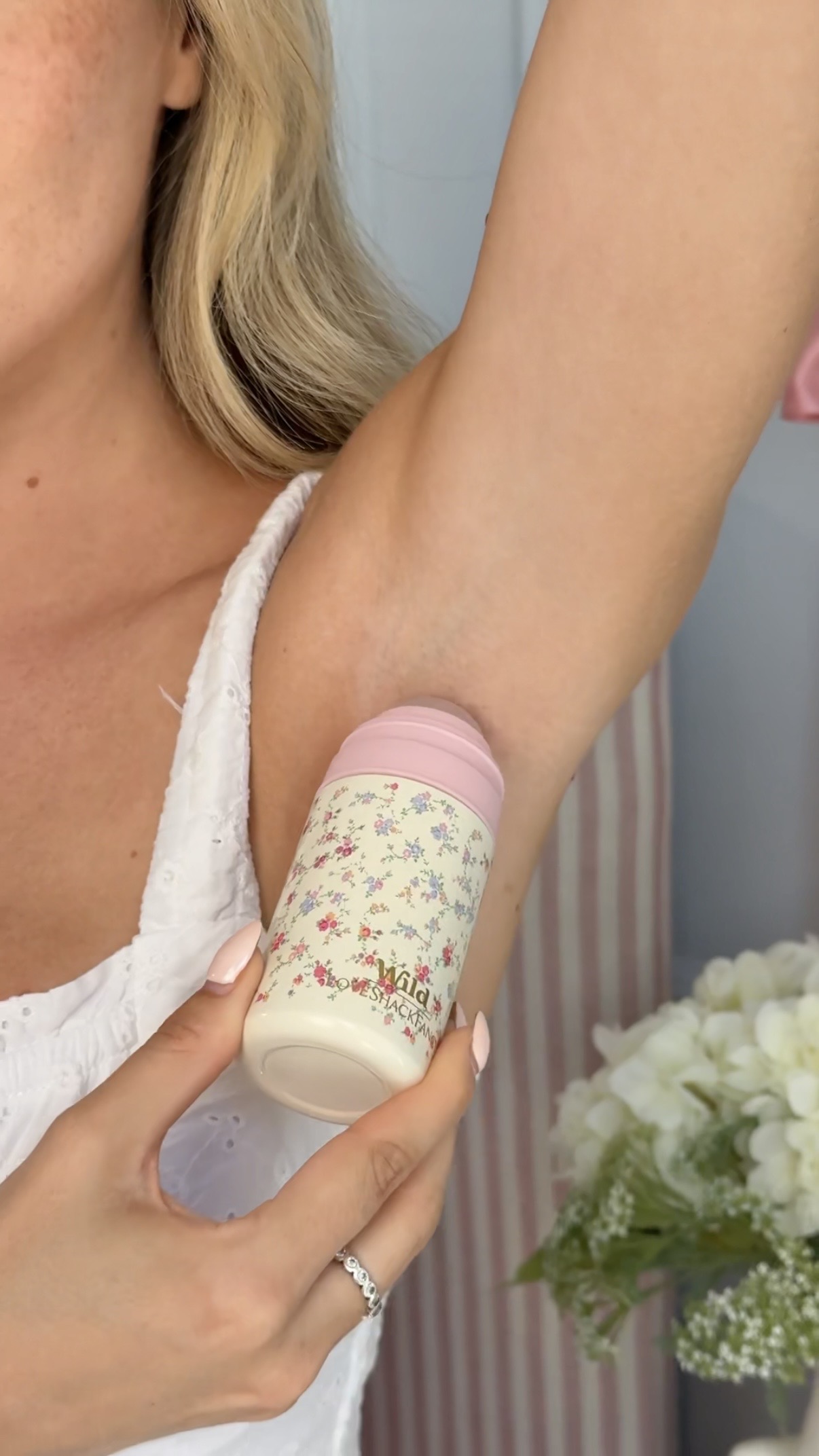 Légende : une femme tenant un flacon de lotion à la main