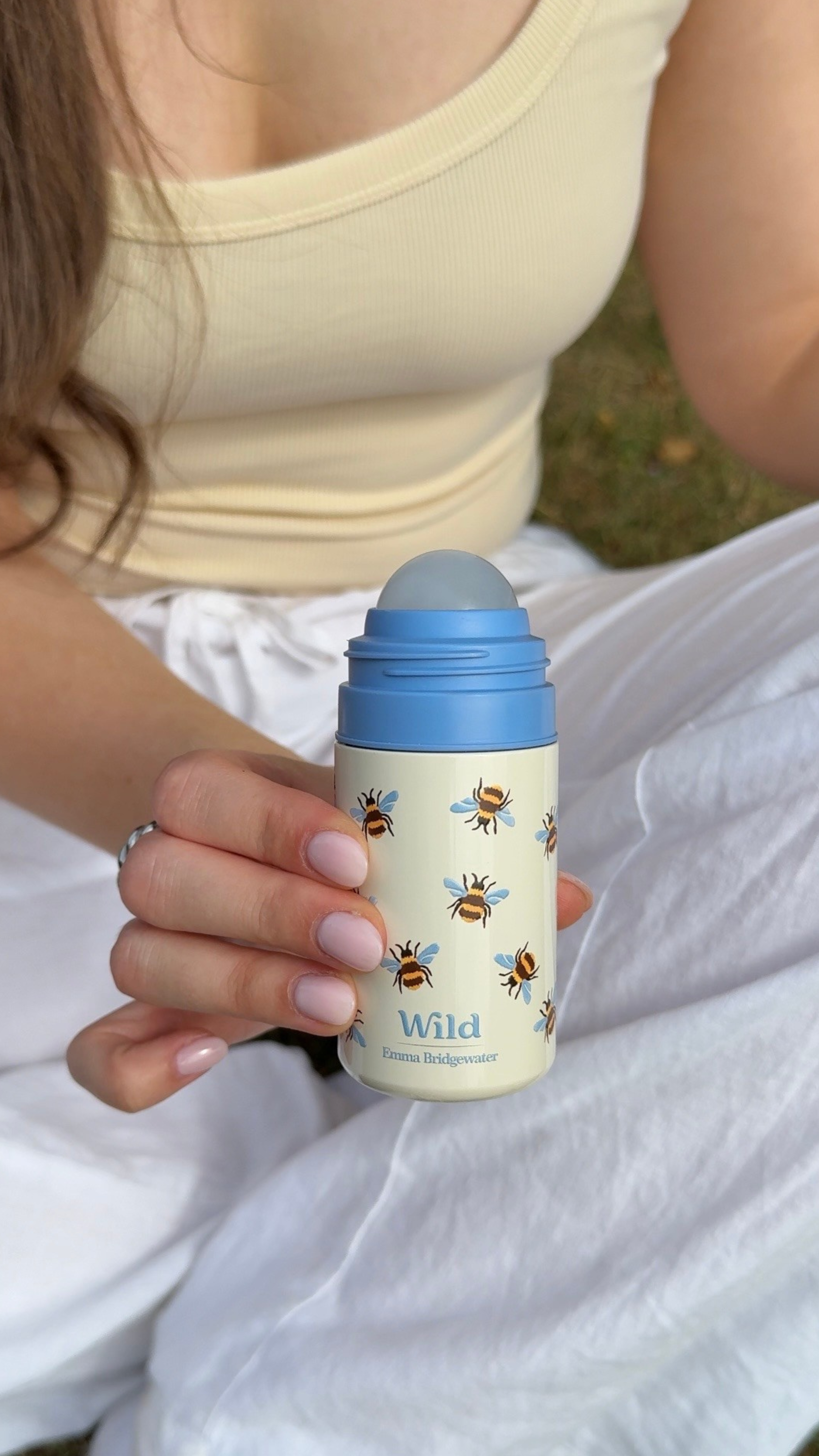 Légende : une femme tenant un biberon orné d'abeilles